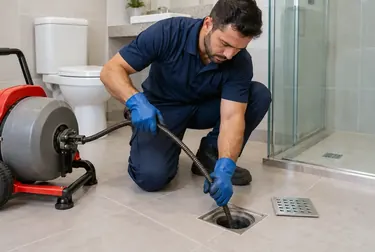 Técnico desentupindo ralo com equipamentos apropriados.